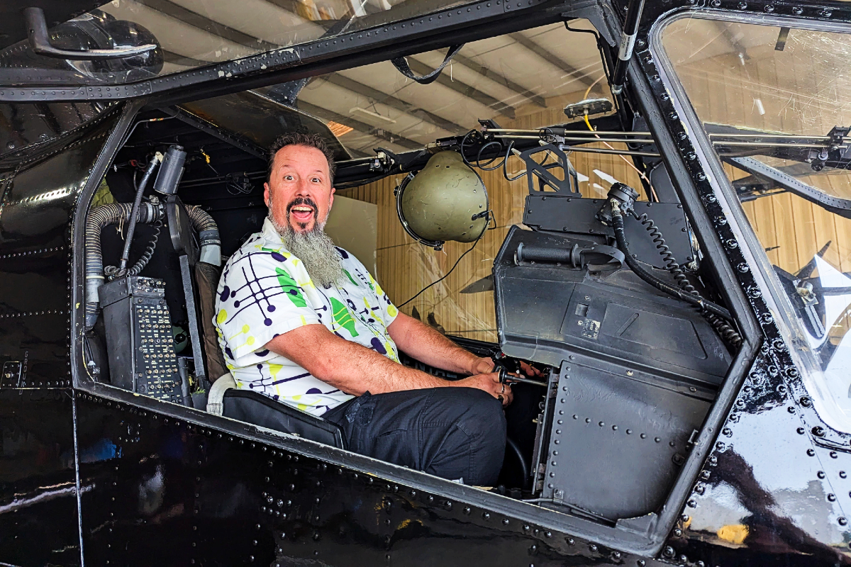 Writer climbs inside helicopter. Historic importance of the AH-1F Cobra at the Army Aviation Heritage Foundation and Flying Museum